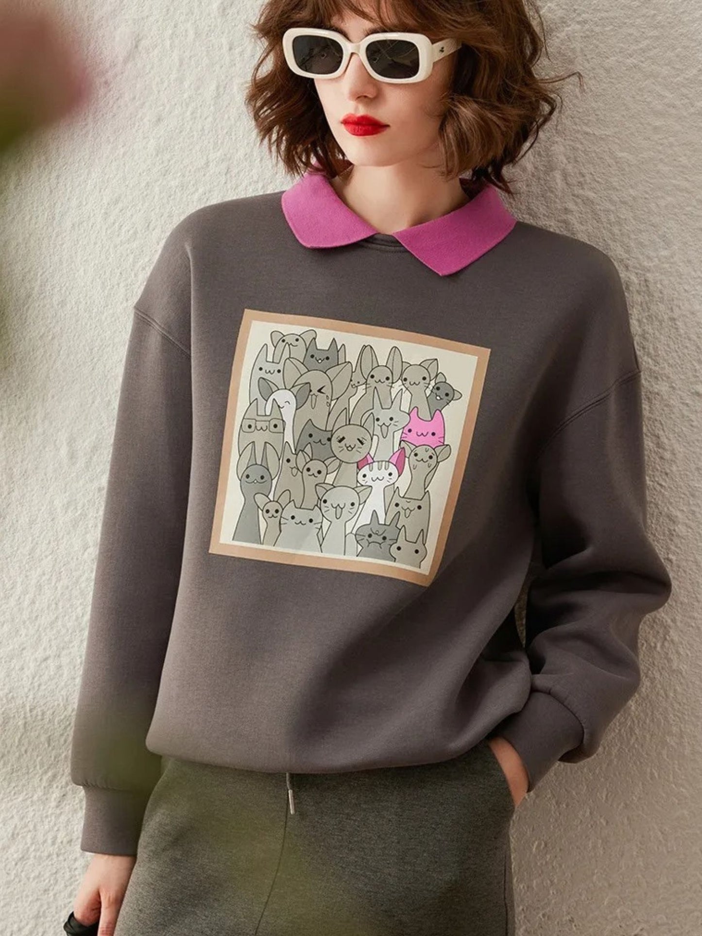 Front view of grey sweatshirt with graphic design, styled with collared shirt
