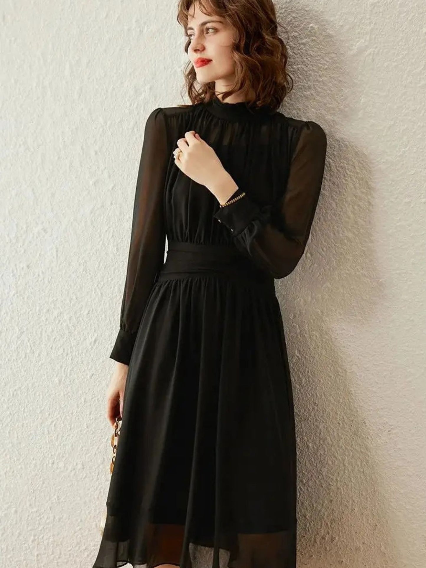 Side angle of black midi dress with sheer pleated fabric