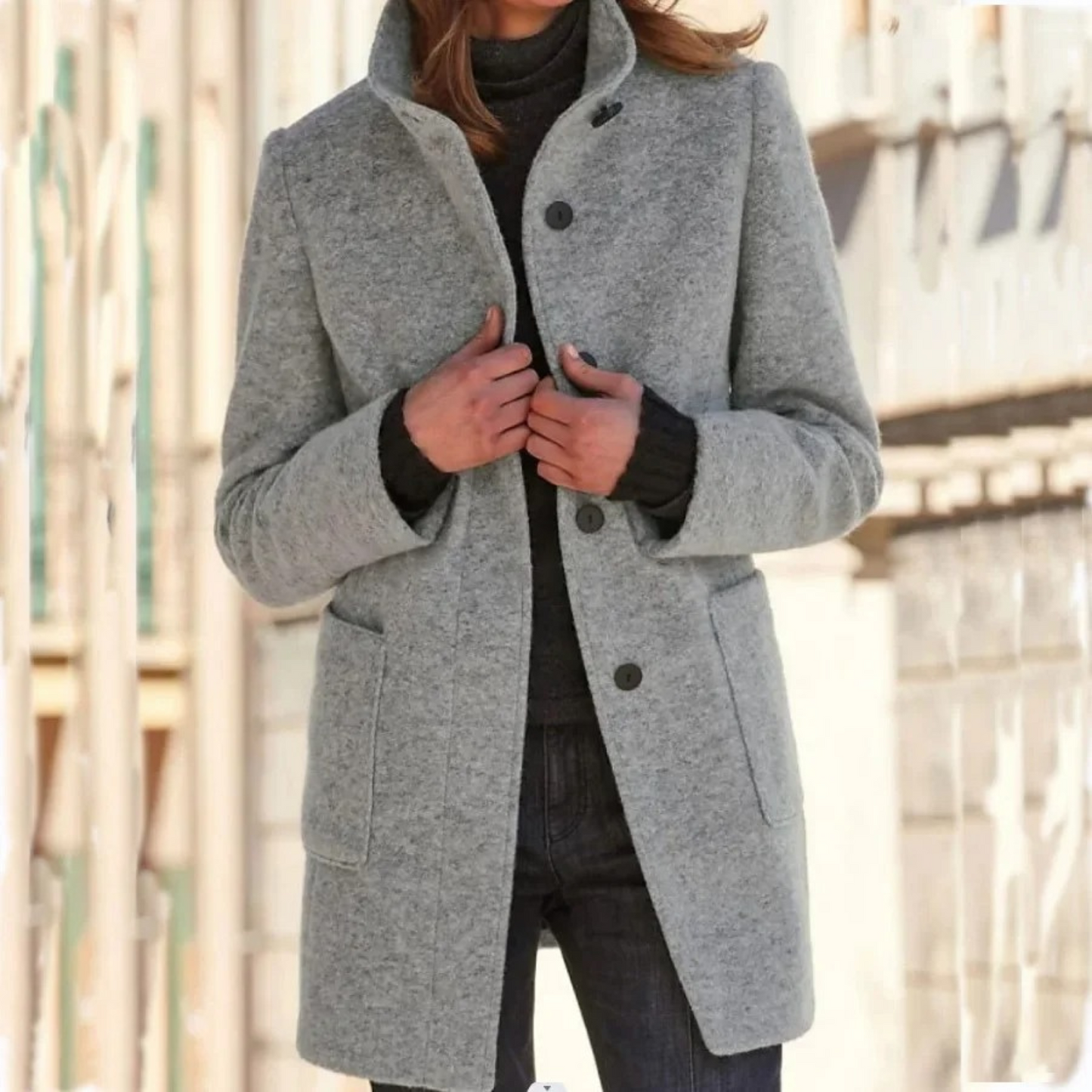 Person wearing a gray coat with a blurred background