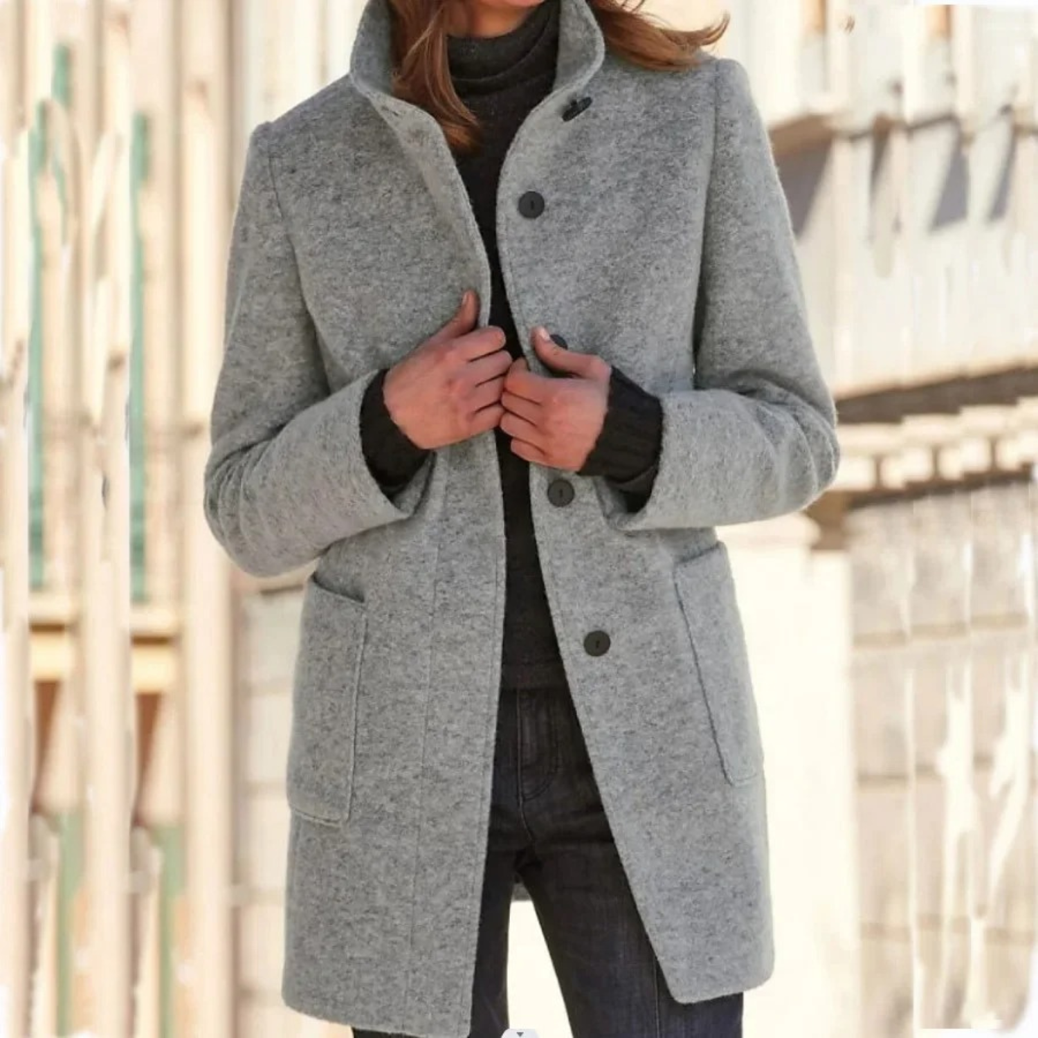 Person wearing a gray coat with a blurred background