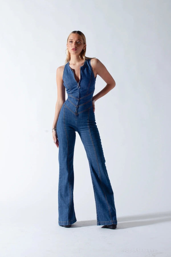 Woman wearing a blue denim jumpsuit on a white background