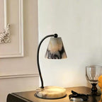 Marble bedside lamp with integrated candle tray and curved metal arm